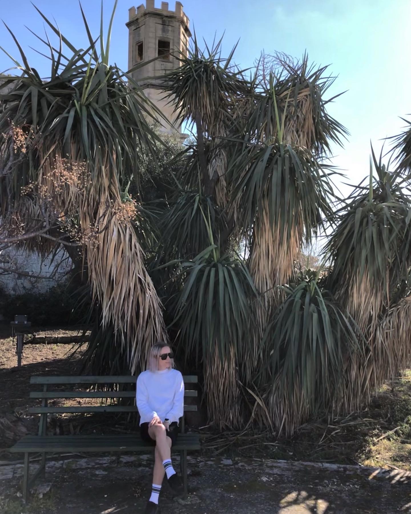 girl siting by palm tree